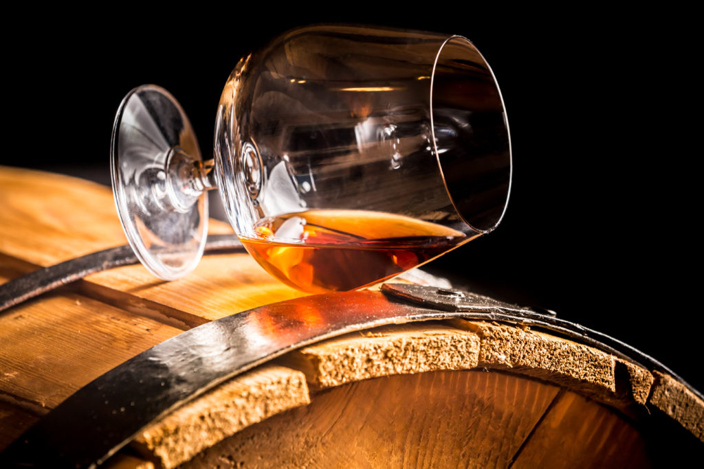 Glass Of Cognac On A Vintage Oak Barrel