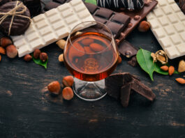 A glass of cognac, and a set of chocolate with cookies and sweets.