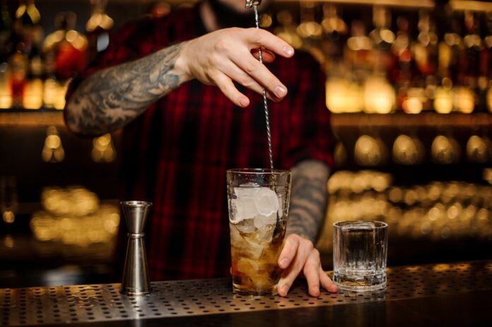 Bartender Stirring a Rusty Nail Cocktail